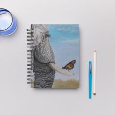 an elephant with a butterfly on it's nose next to a pencil and marker