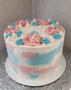 a cake decorated with pink, blue and white icing