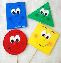 four different colored paper faces on sticks