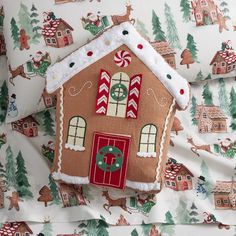 a gingerbread house pillow on a bed