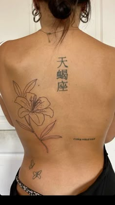 the back of a woman's body with tattoos on it