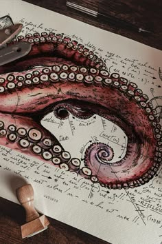 an octopus drawing on top of a piece of paper next to a rubber stamper