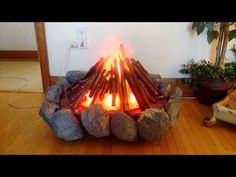 a fire pit sitting on top of a wooden floor next to a potted plant