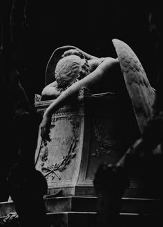 an angel statue sitting in the middle of a cemetery