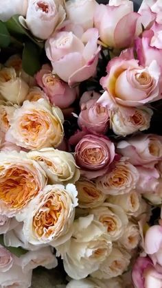 a bunch of pink and white flowers are in the middle of a pile on the ground