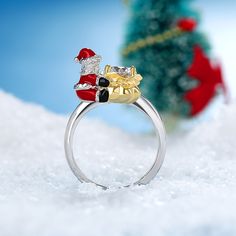 Enjoy the magic of Christmas with this ring. Inspired by Santa Claus, this ring in Hug Me® collection shows a baby with red Christmas hat, red Christmas clothes. Crafted in sterling silver, this one features this lovely Christmas baby that hugged the center stone. You will instantly fall in love with this cute design. You will find more adorable and creative designs in our Hug Me® collection.Carat Weight: 1.9 ctStone Size: 6.5 mmStone Type: Jeulia® StoneNumber of Stones: 1 Stone Color: Diamond WhiteStone Shape: RoundWeight: 5.25 gWidth: 2.8 mmHeight: 9.9 mmThickness: 1.6 mmMaterial: 925 SilverPlating Color: Silver, Yellow Gold Christmas Rings, Baby Candy, Christmas Ring, Christmas Clothes, The Magic Of Christmas, Magic Of Christmas, Candy Bags, Hug Me, Christmas Hat