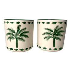 two white cups with green palm trees on them