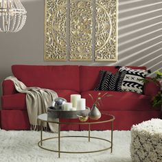 a living room with red couches and white rugs on the floor next to a chandelier