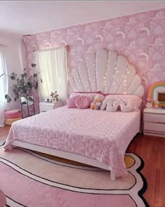 a pink and white bedroom with an ocean themed bed, dressers, mirror and rug