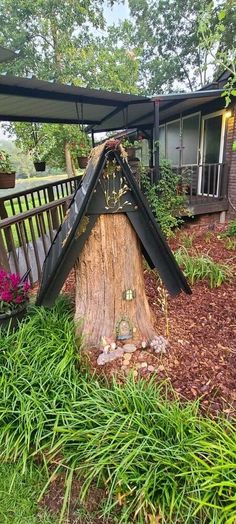 a tree stump with a house in the background