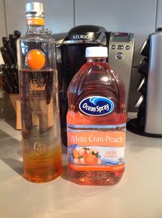 a bottle of orange juice next to a plastic water bottle