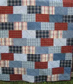 a blue and red patchwork quilt on the grass