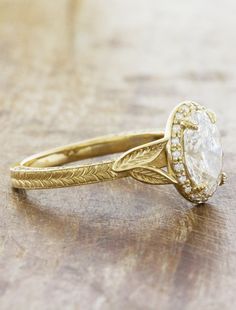 a yellow gold engagement ring with an oval diamond