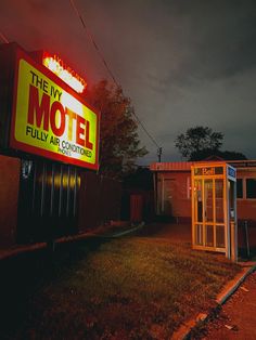 a motel sign is lit up in the dark with red lights on it's side