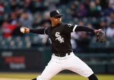 a baseball player pitching a ball on top of a field in front of a crowd