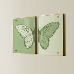 two green and white butterfly paintings hanging on a wall