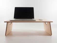 a laptop computer sitting on top of a wooden desk