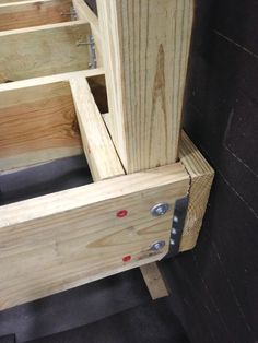 two wooden boxes sitting on top of each other next to a black wall and floor