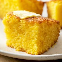 a piece of cornbread on a plate with butter and icing sitting next to it