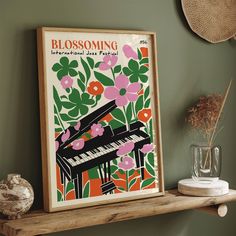 a framed poster on a shelf next to a vase with flowers and plants in it