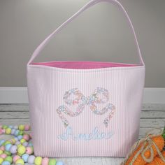 a pink bag with two hearts on it next to some candy balls and a pumpkin