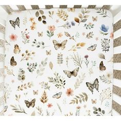 a crib sheet with butterflies and flowers on it