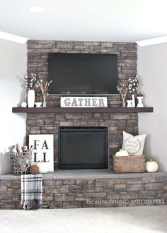 a fireplace with a tv above it and some decorations on the mantel in front of it