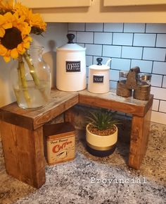 a kitchen counter with sunflowers and jars on it