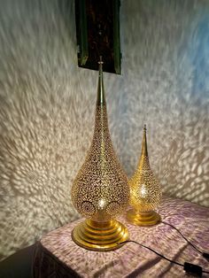 two golden vases sitting on top of a table