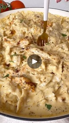 a person holding a fork in a bowl filled with macaroni and cheese sauce