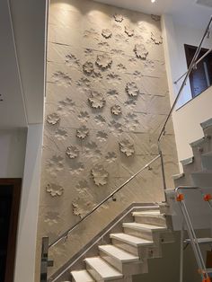 a white staircase leading up to a wall with flowers on it