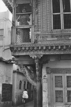 an old black and white photo of a person standing on the balcony of a building