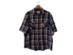 "80's Sears Vintage Flannel Short Sleeve Acrylic Shirt with Pockets Blue Brown Burgundy White Plaid Men's Large ☆ SIZE: Men's Large ☆ MEASUREMENTS (inches, item lying flat): ✄ Length: 29\" ✄ Width (armpit to armpit): 25\" ✄ Arms (armpit seam to cuff): 8 1/2\" ☆ COLOR: Blue, Burgundy, White, Orange ☆ MATERIAL: Unknown, feels like acrylic ☆ BRAND: Sears ☆ CONDITION: The item is vintage and previously loved.  There is no visible damage to the item. Thanks for checking out this listing! Be sure to v Affordable Vintage Flannel Shirt With Buttons, Cheap Vintage Plaid Flannel Shirt, Short Sleeve Plaid Flannel Shirt With Pockets, Plaid Short Sleeve Flannel Shirt With Pockets, Vintage Blue Flannel Shirt, Short Sleeve Flannel, Flannel Shorts, Vintage Flannel, Orange Material