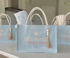 three bags with tassels on them sitting on a counter in front of a kitchen