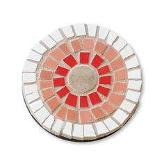 a red and white mosaic tile coaster on a white surface with an orange circle in the center