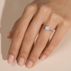 a woman's hand with a diamond ring on top of her finger and the other hand