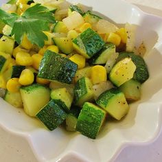 a white bowl filled with cucumber and corn