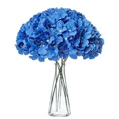 a glass vase filled with blue flowers on top of a table