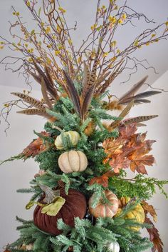 a christmas tree decorated with fall foliage and pumpkins