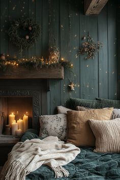 a bed covered in blankets and pillows next to a fireplace with lit candles on it