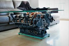 an engine sitting on top of a glass table in front of a couch and coffee table