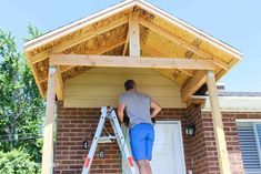 a man standing on a ladder in front of a house