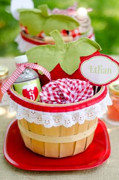 a wooden basket filled with personalized items on top of a red table cloth covered plate