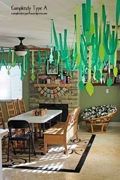 a dining room filled with lots of furniture and hanging paper streamers above the table