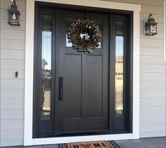 a black front door with a wreath on it