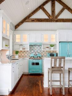 a kitchen with white cabinets, blue appliances and wooden floors is pictured in this image