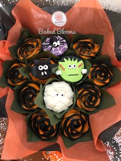 some cupcakes in the shape of zombies on top of orange flowers and leaves