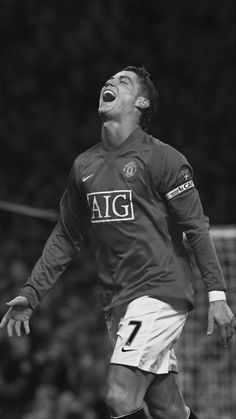 a black and white photo of a soccer player with his mouth wide open in celebration