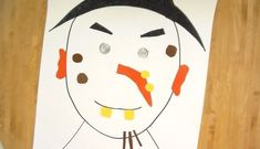 a child's drawing of a face on a piece of paper with black hair