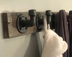 a towel hanging on a wooden rack next to some towels